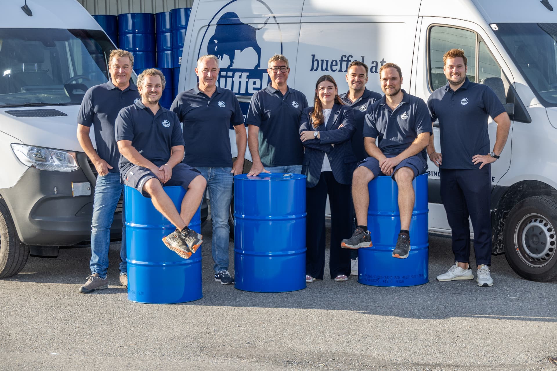 Das Büffel-Team vor den Firmenfahrzeugen und blauen Fässern beim Besuch zum KMU-Preis 2026